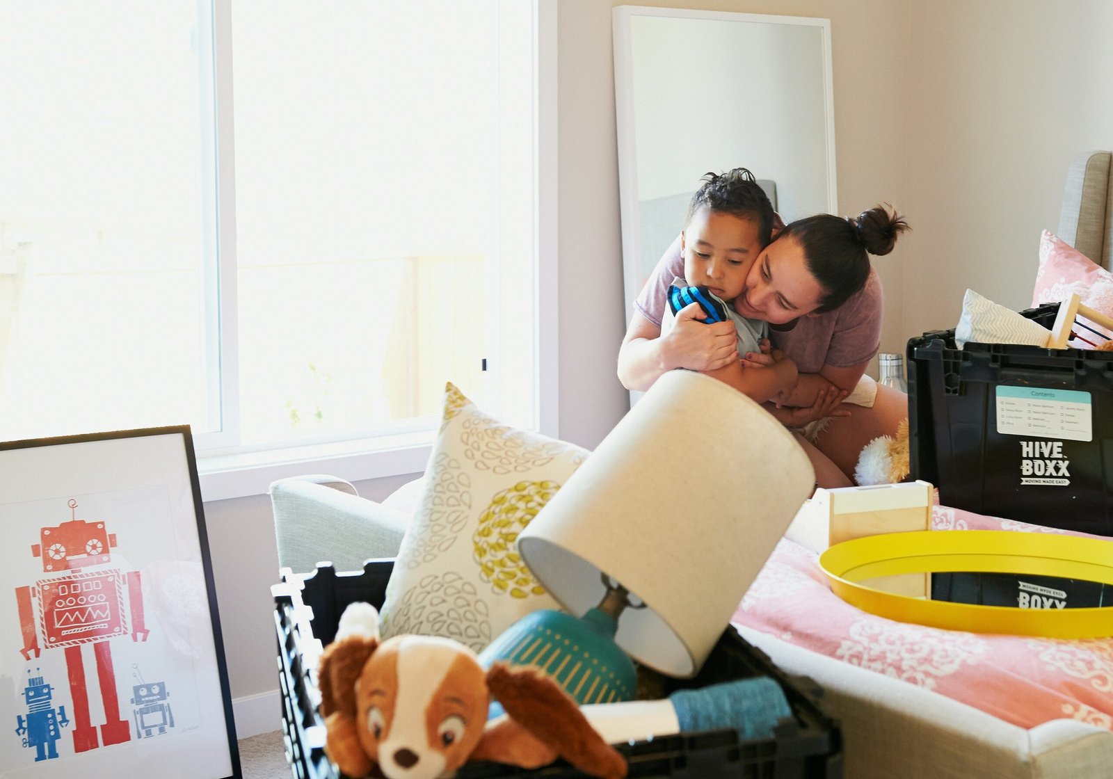 woman in white shirt carrying baby in blue shirt