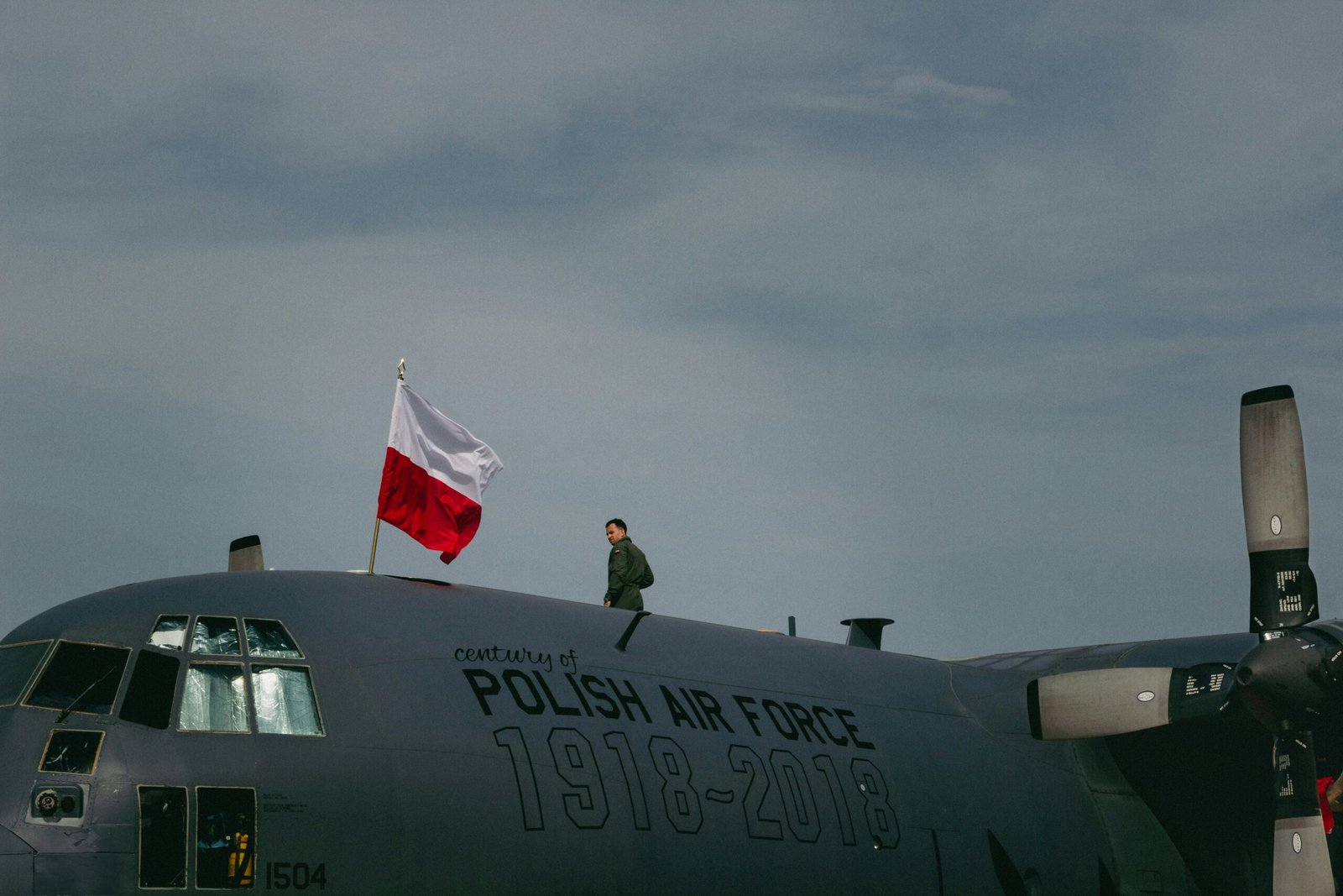a man standing on top of a polish air force plane
