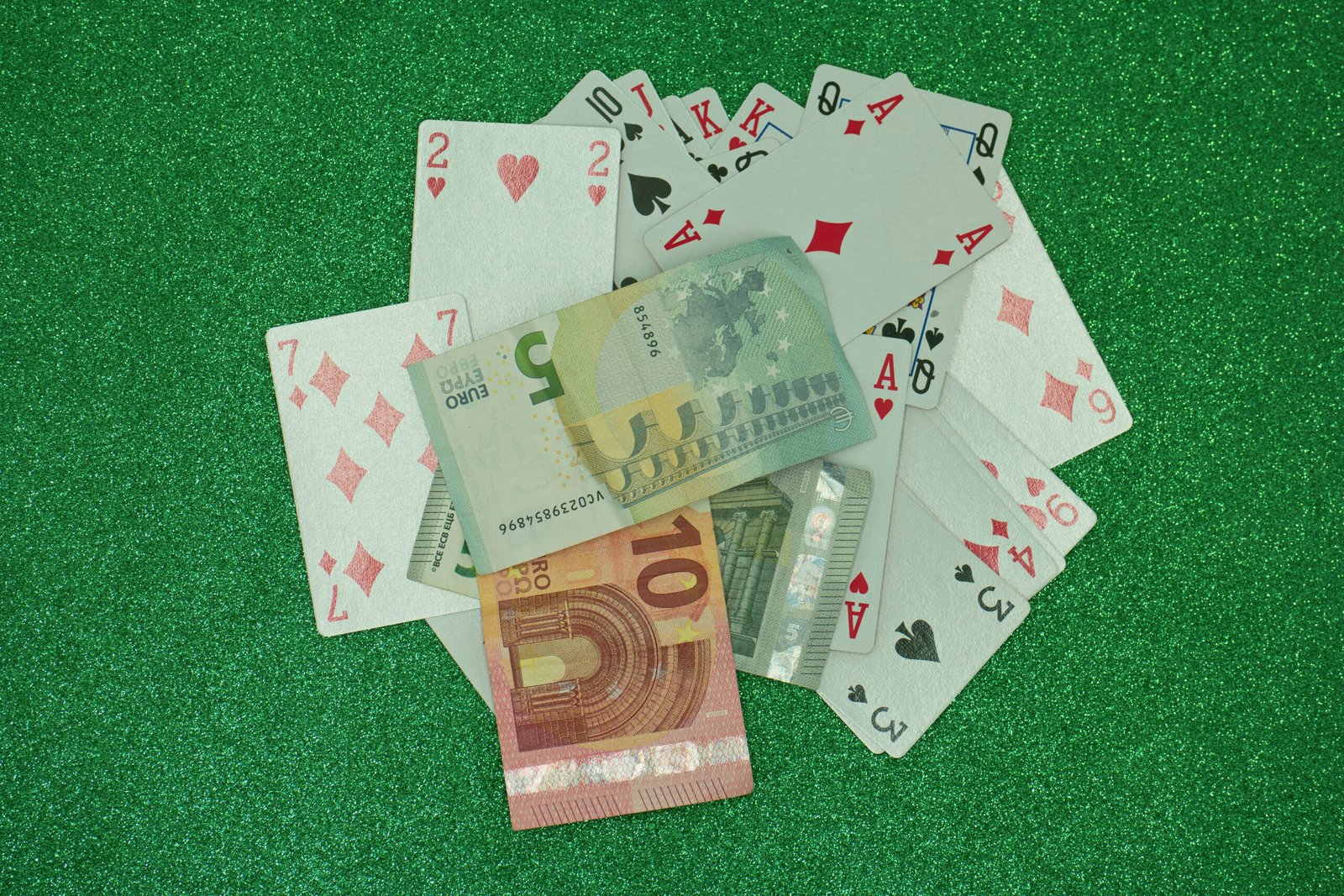 a pile of playing cards sitting on top of a green field