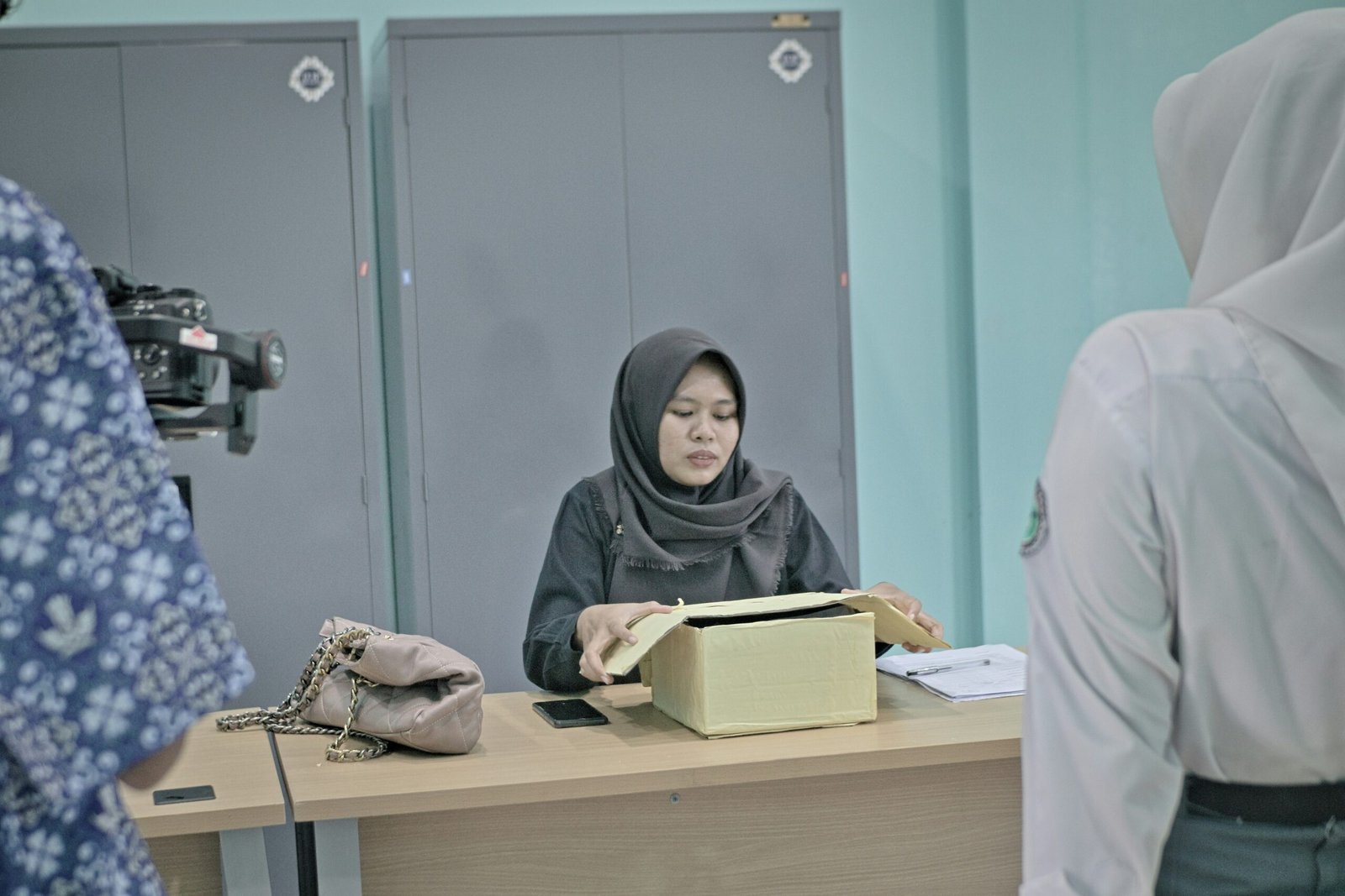 Woman in hijab at desk with papers
