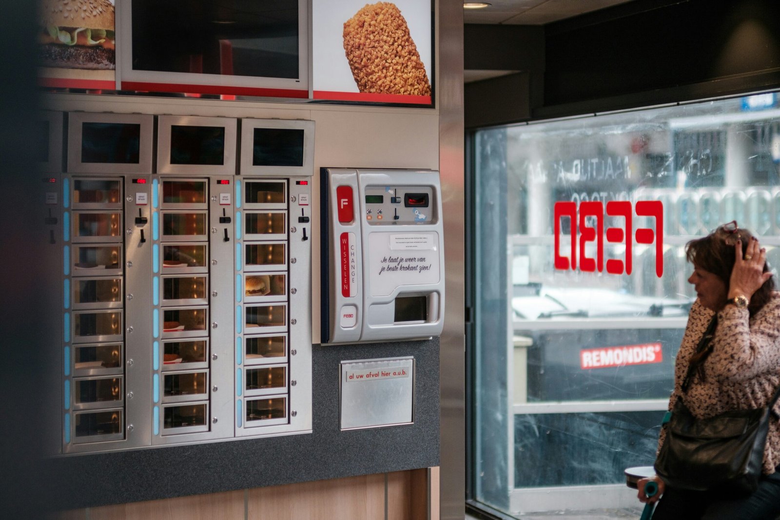 a woman talking on a cell phone in front of a vending machine