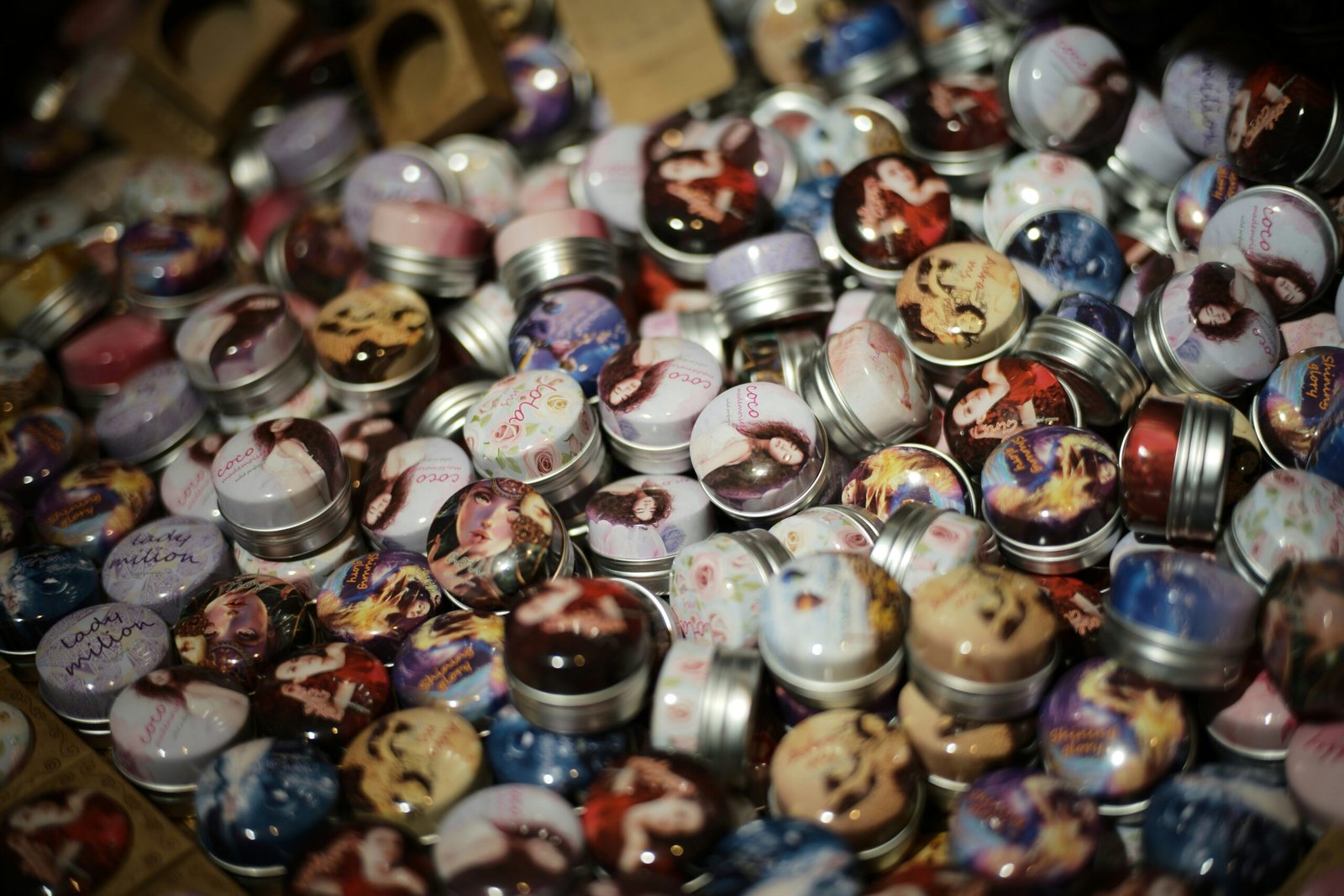 A pile of small, decorative tins with colorful lids.