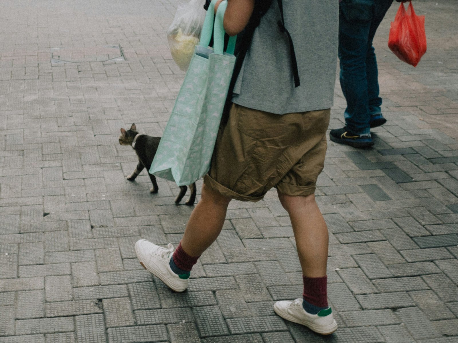 a man walking down a street while holding onto a bag