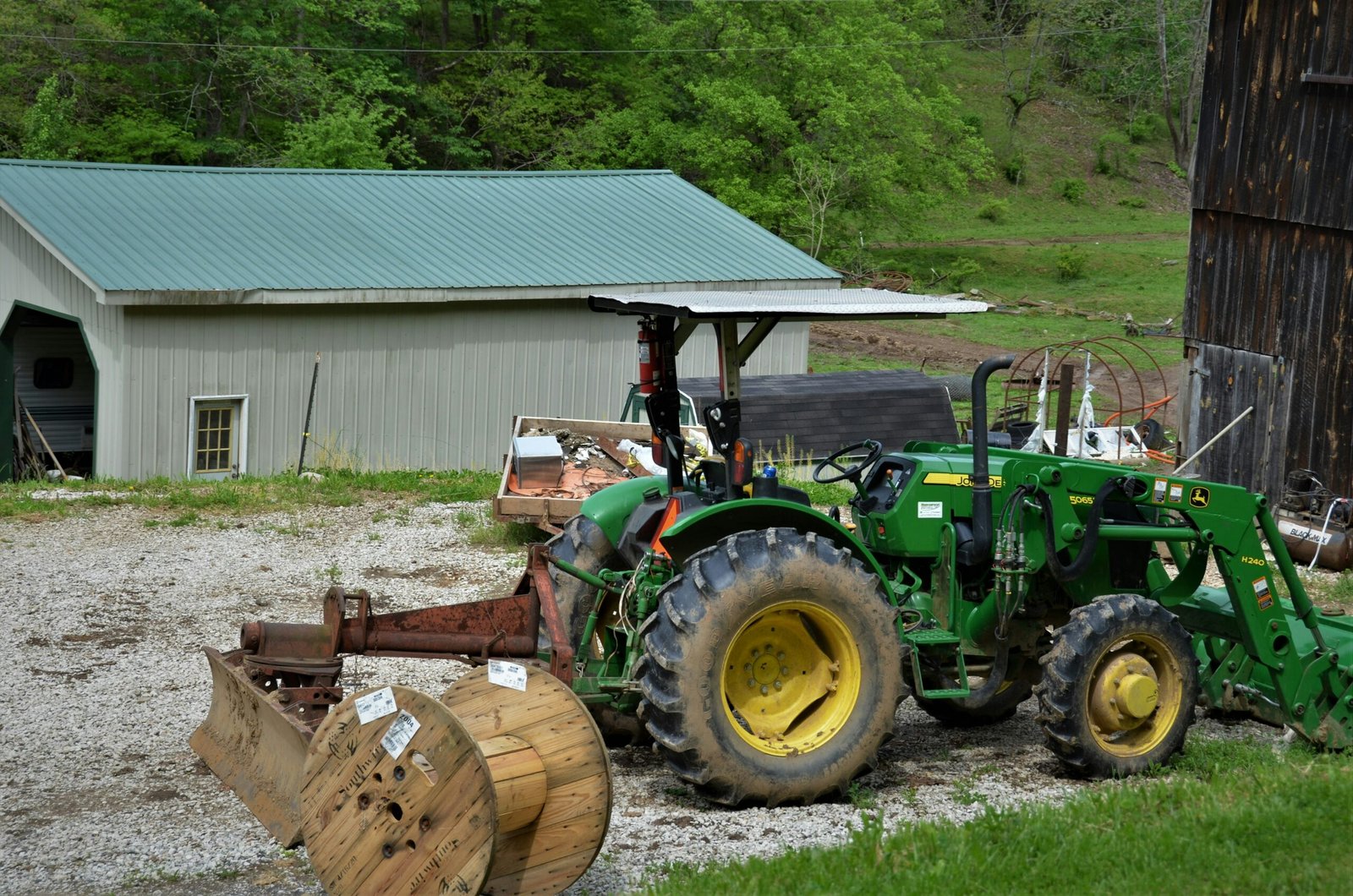 green and yellow tractor on green grass field during daytime