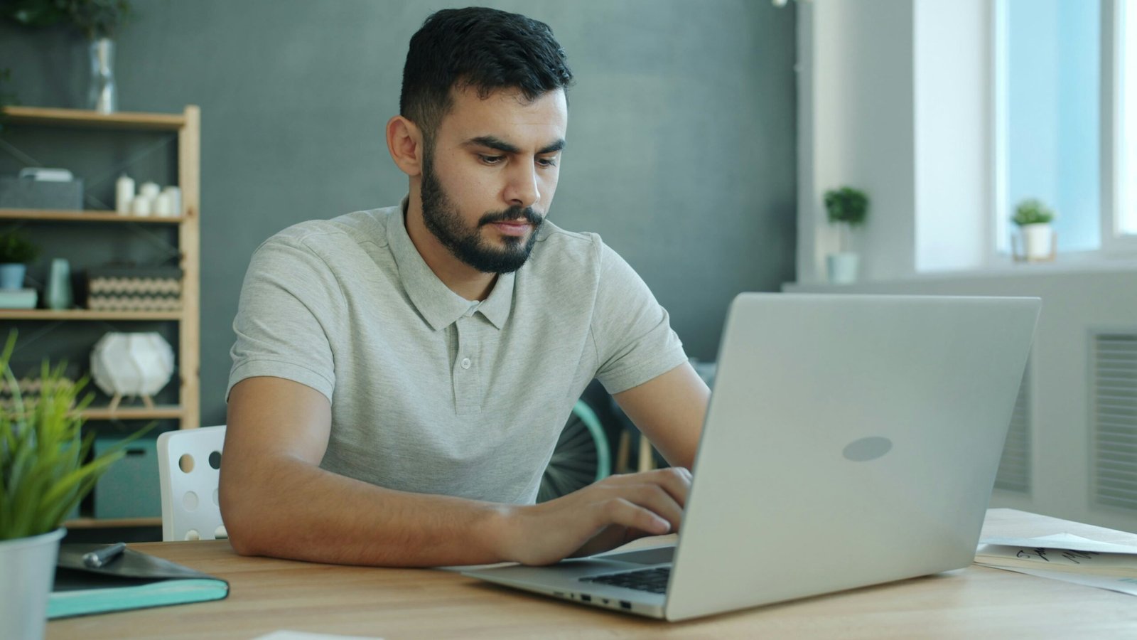 Man typing on a laptop at a desk.