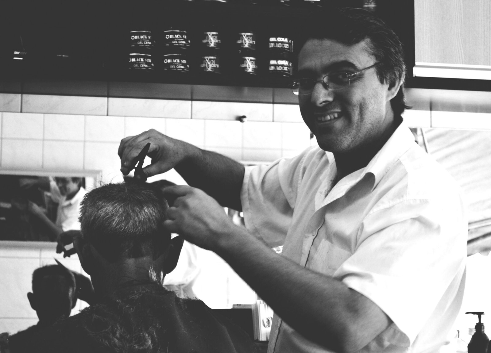a man cutting another mans hair in a barber shop