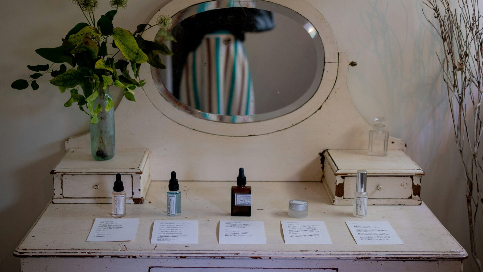 Vintage vanity with skincare products and flowers.