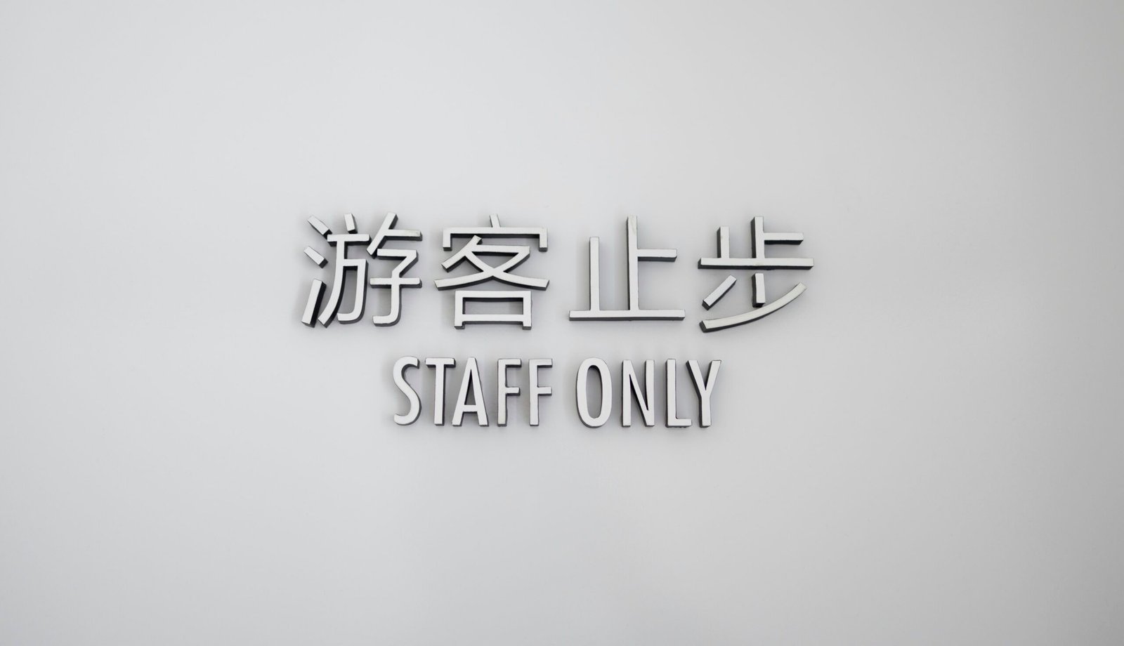 a white wall with a sign that says staff only