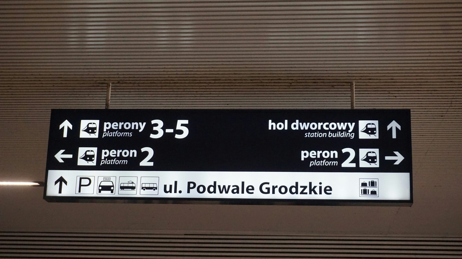 Directional signs indicate platforms and parking.