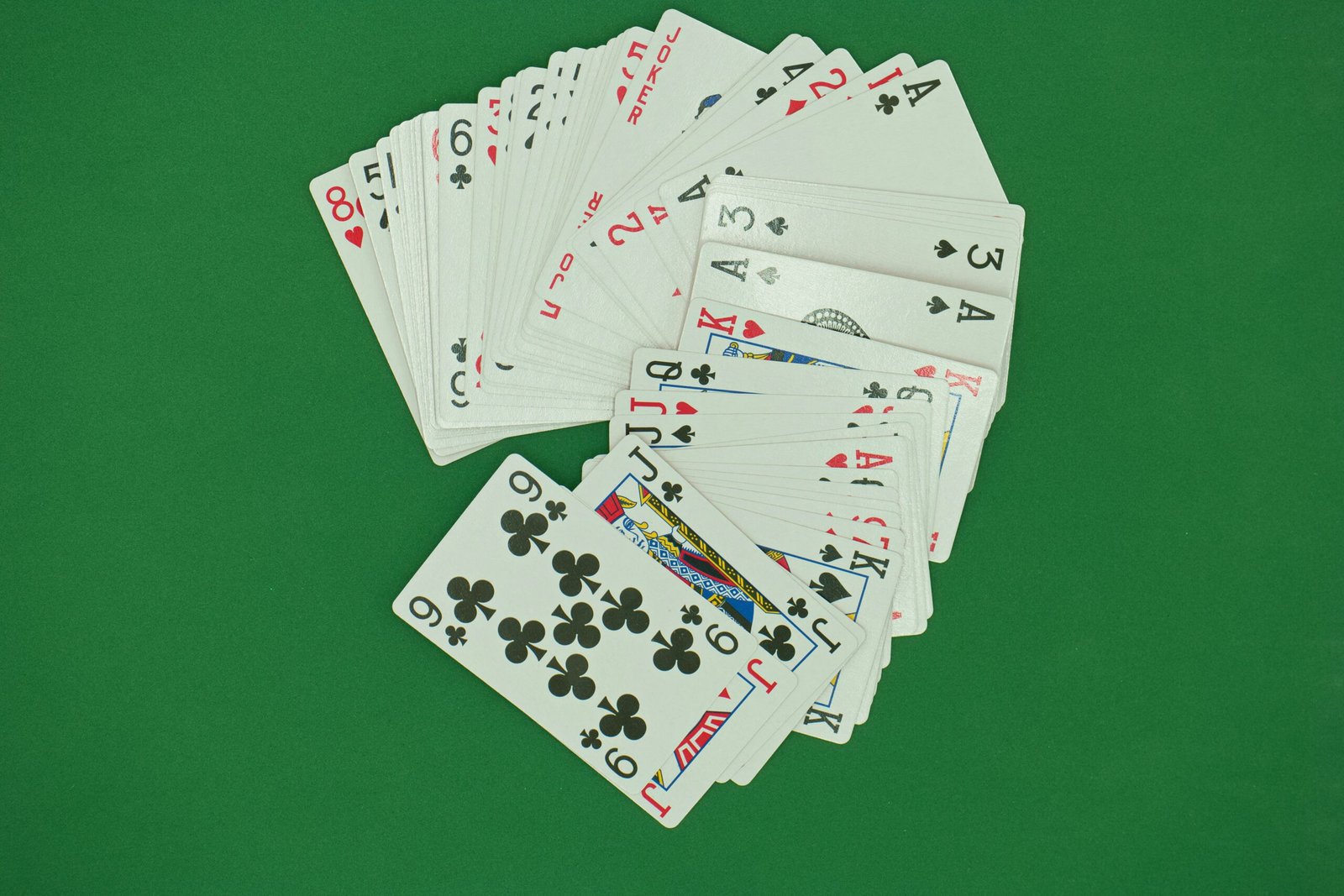 a pile of playing cards sitting on top of a green table