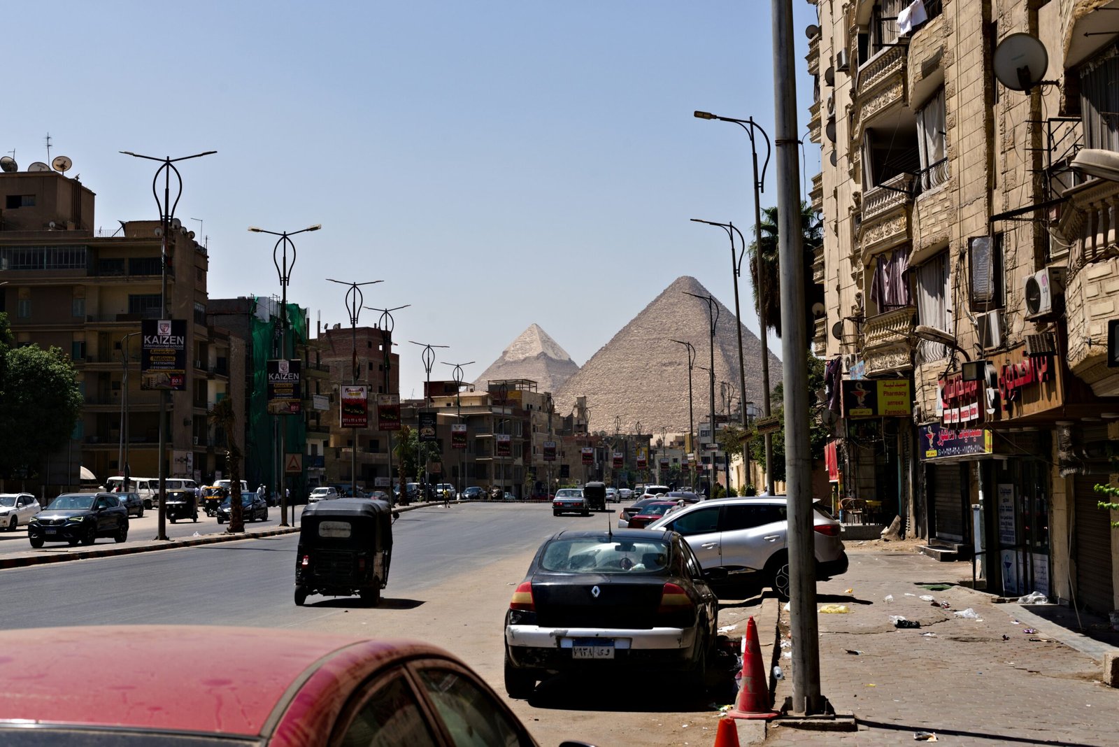 Pyramids visible over buildings and street traffic