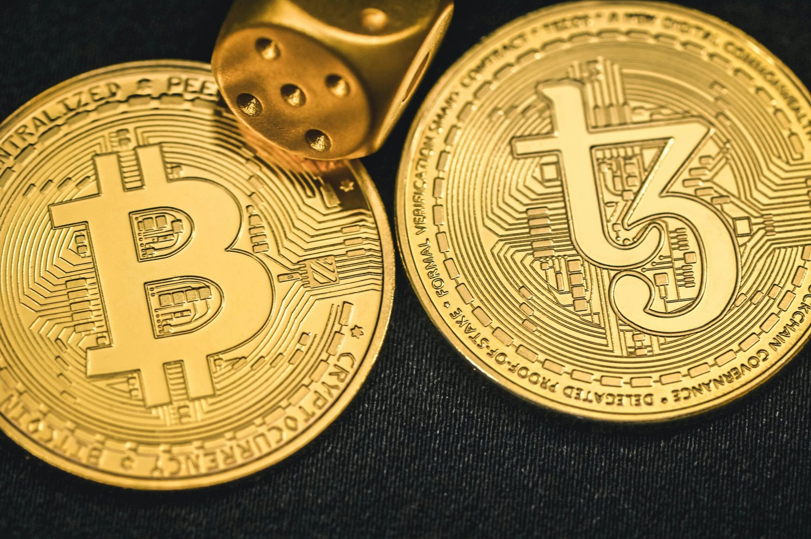 two gold bitcoins sitting next to each other