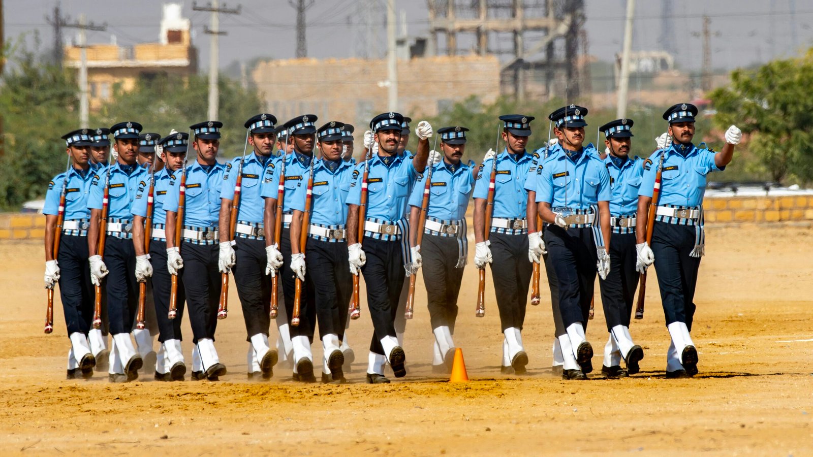 Air force personnel marching with rifles on parade ground