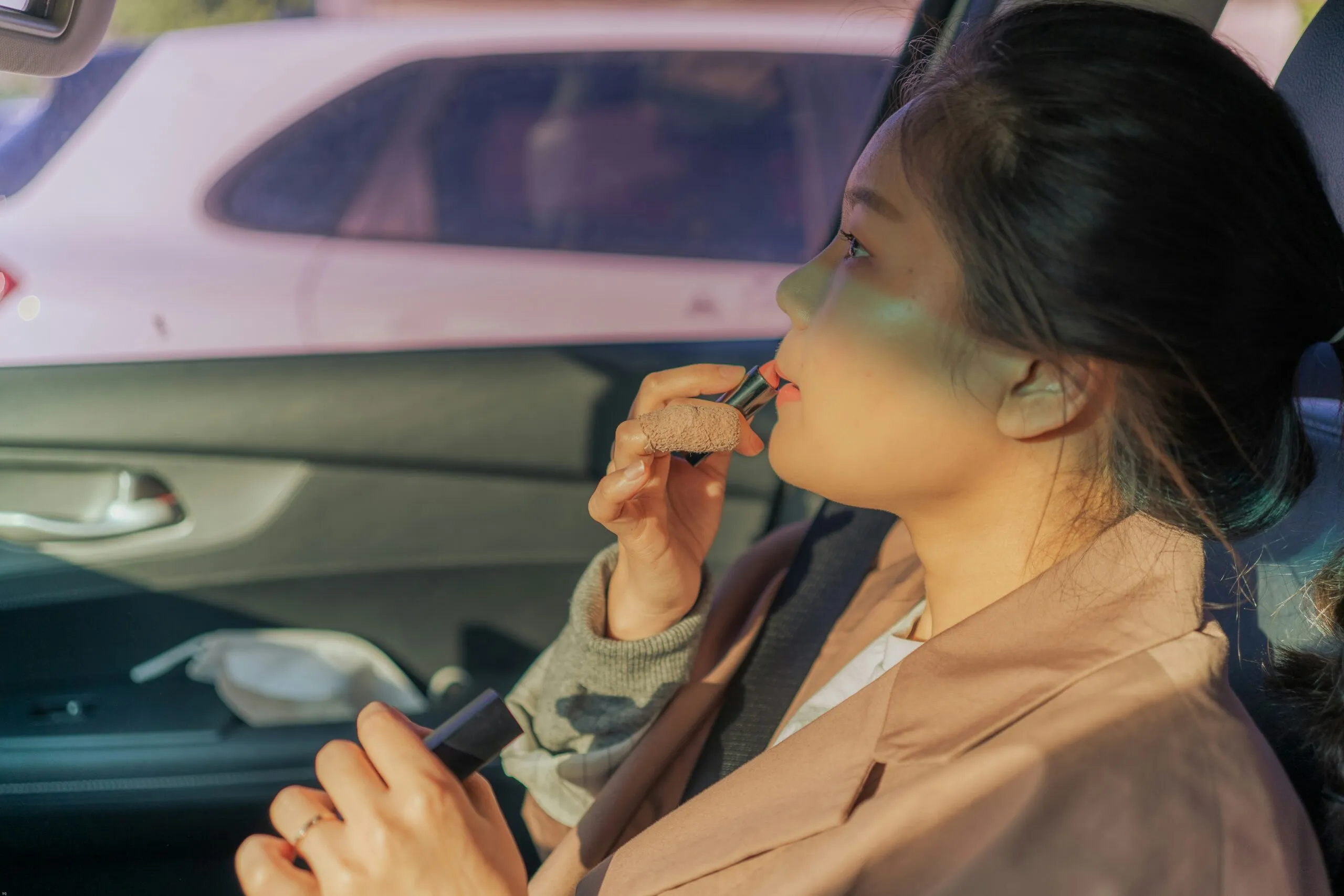 woman in beige coat sitting on car seat