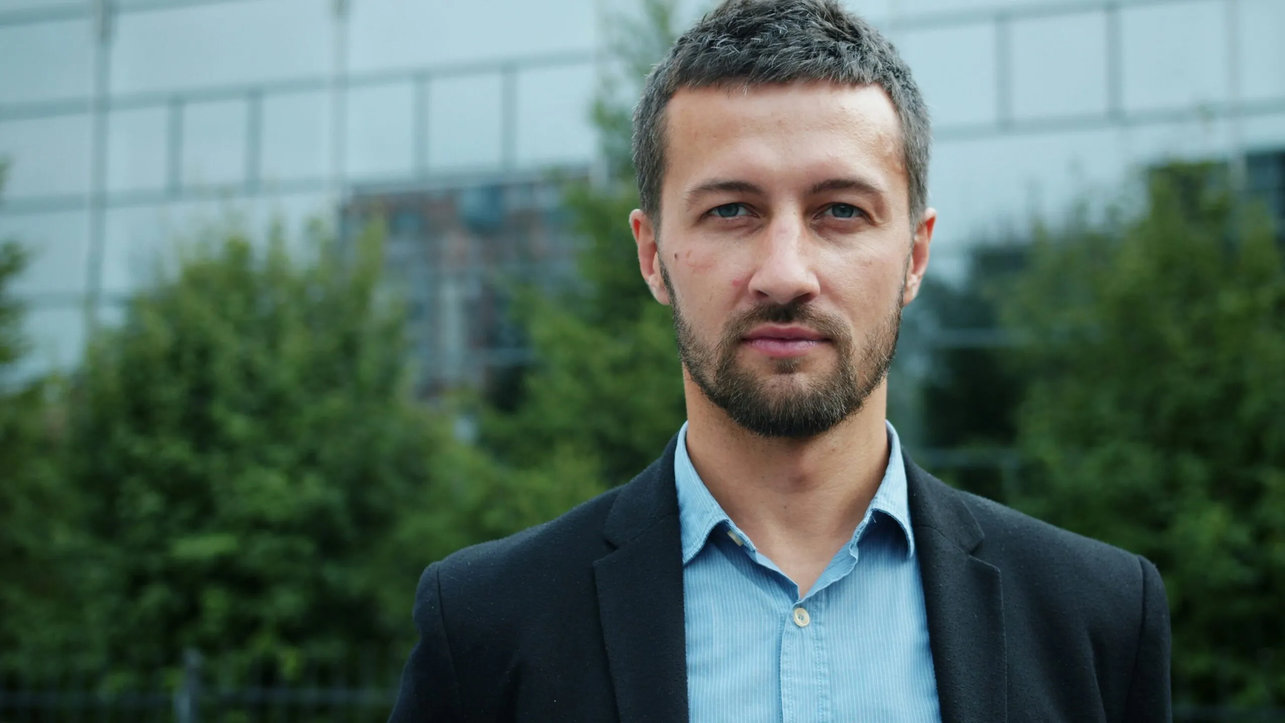 Man in suit standing outside modern building