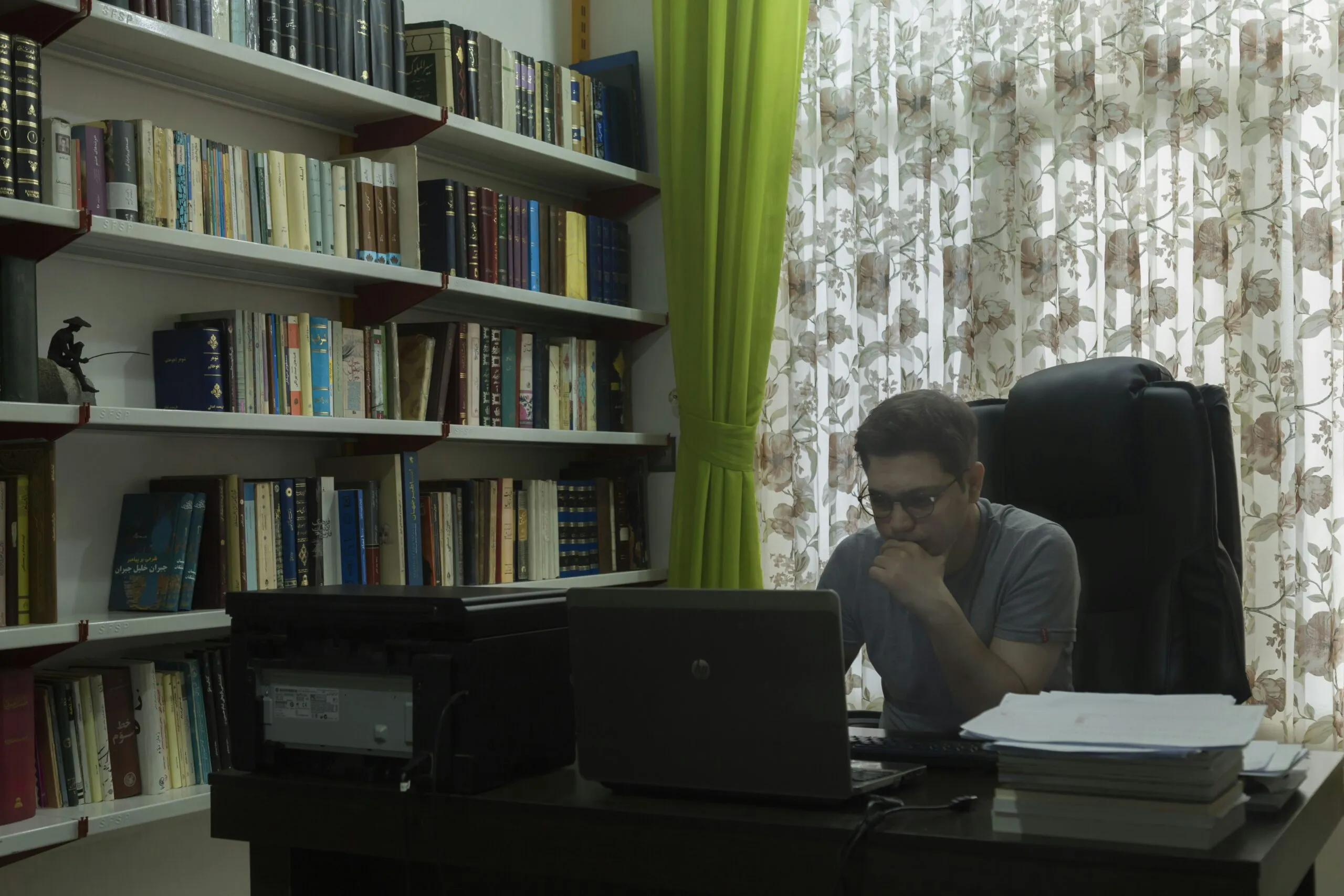 a man sitting at a desk in front of a laptop computer