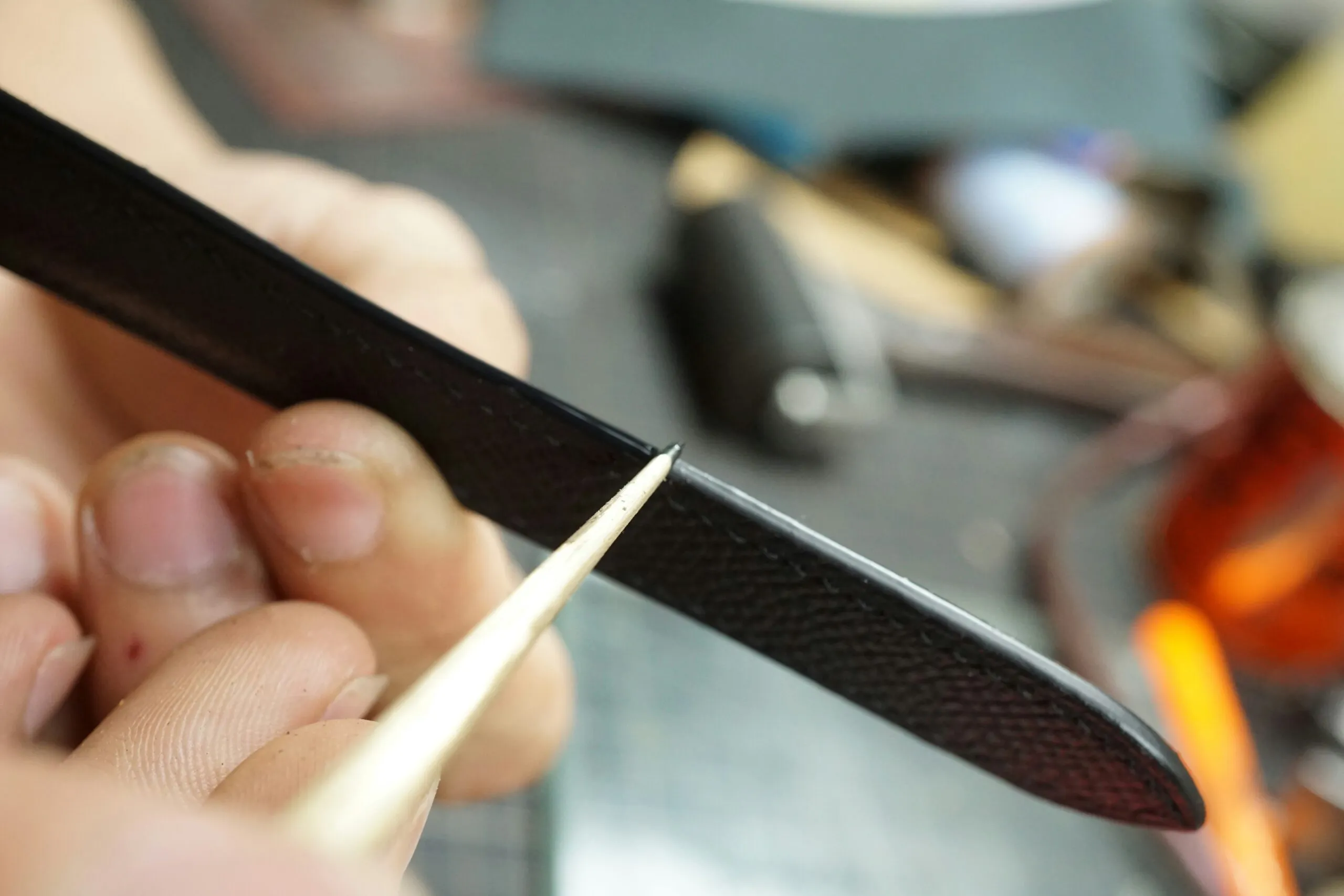 a close up of a person cutting a piece of metal