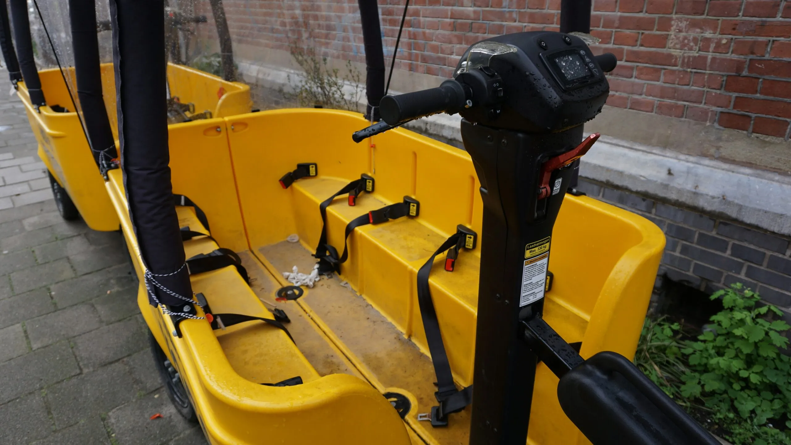 a row of yellow seats sitting next to a brick wall