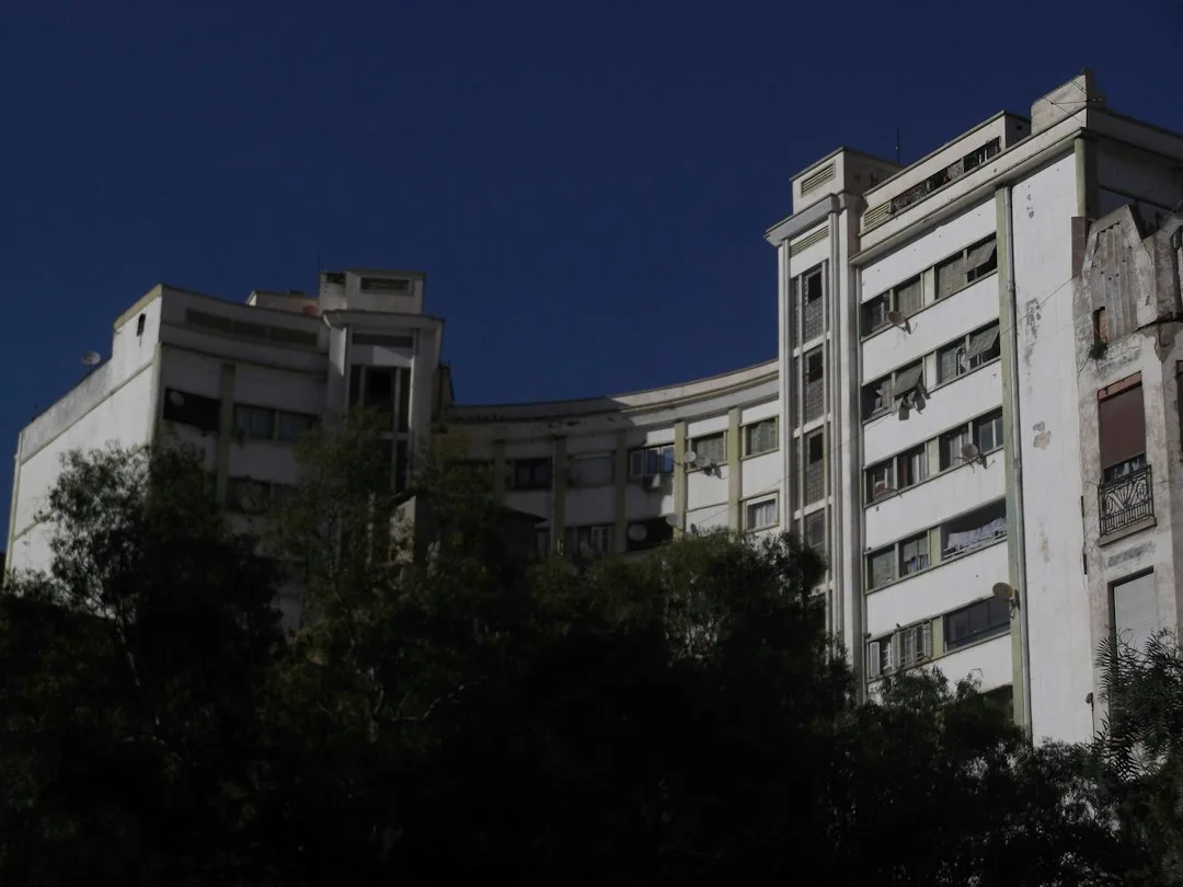 Modern white buildings against a clear blue sky.