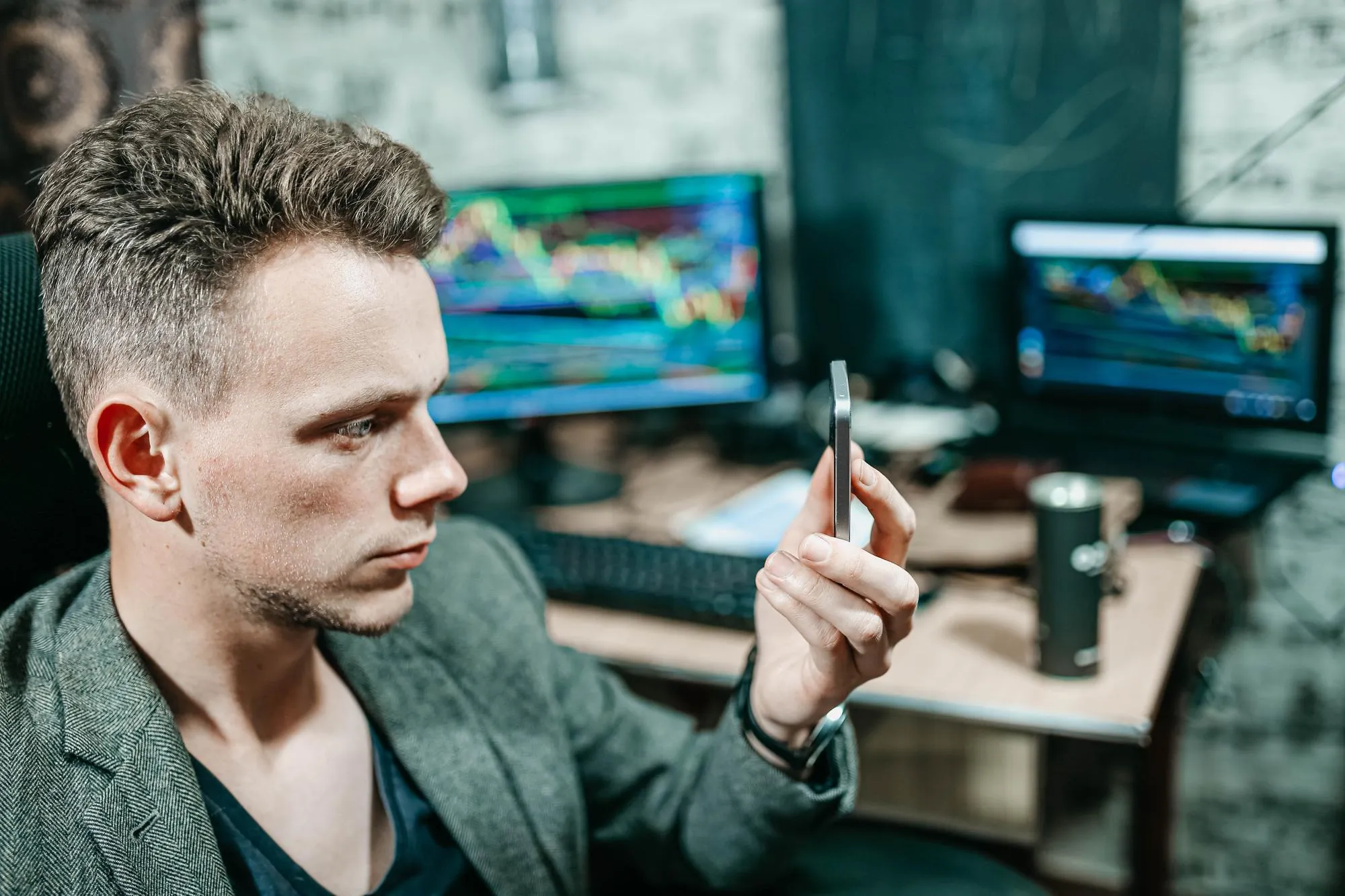 male trade broker sits at a computer and watches the chart of changes in the exchange rate an