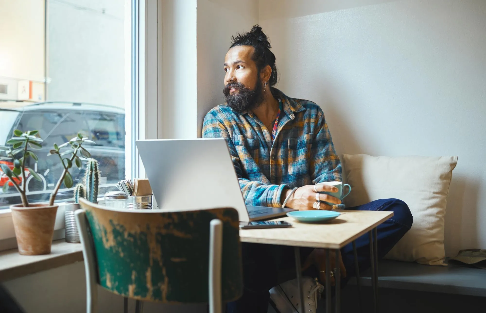 Man laptop and coffee shop window for remote work wifi and creative thinking working online Entrepreneur person think of inspiration or idea at table for social media networking and planning