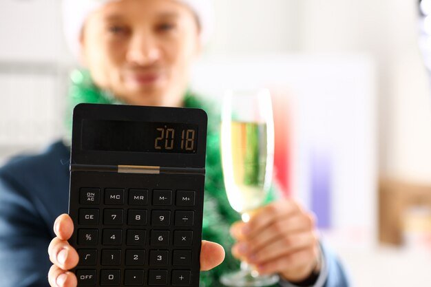 Man in suit hold in arm calculator with 2018 year