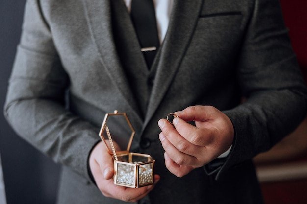 A man in a suit holding a ring in a box