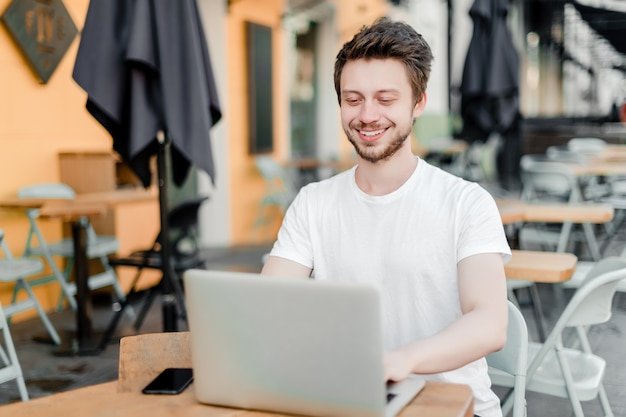 Man using laptop for remote work in cafe
