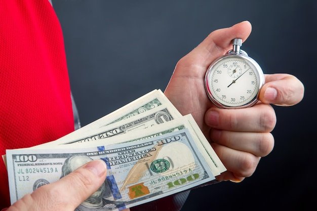 Mechanical analog stopwatch and dollars in a businessman hand Part time accuracy for business business and finance time