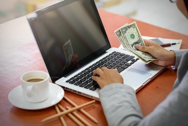 Midsection of businesswoman using laptop on table