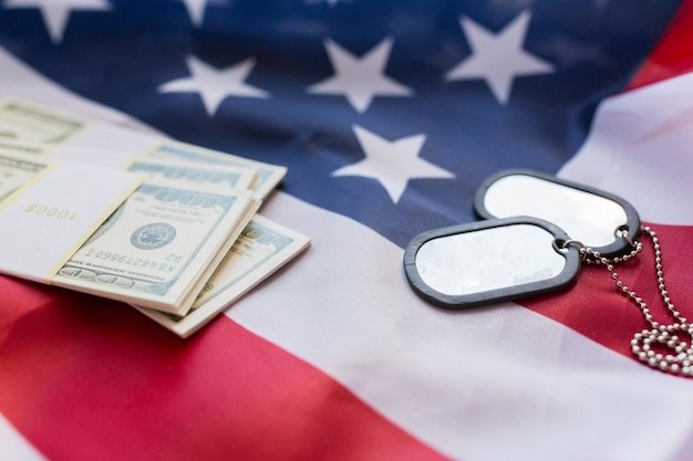 military forces, recruitment, financing and national service concept - close up of american flag, dollar money and military badges