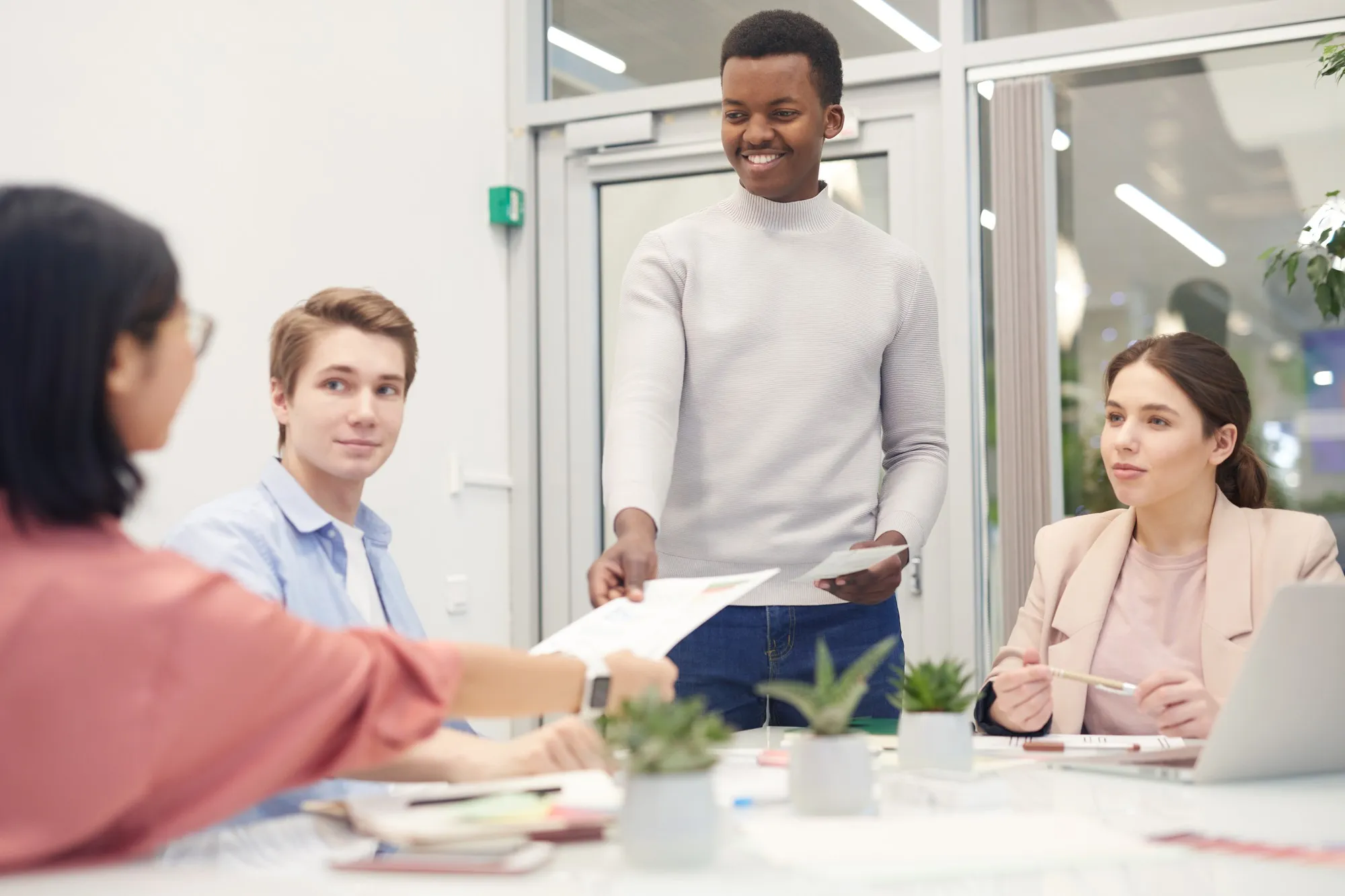 Multi-ethnic group of young business people collaborating on work project