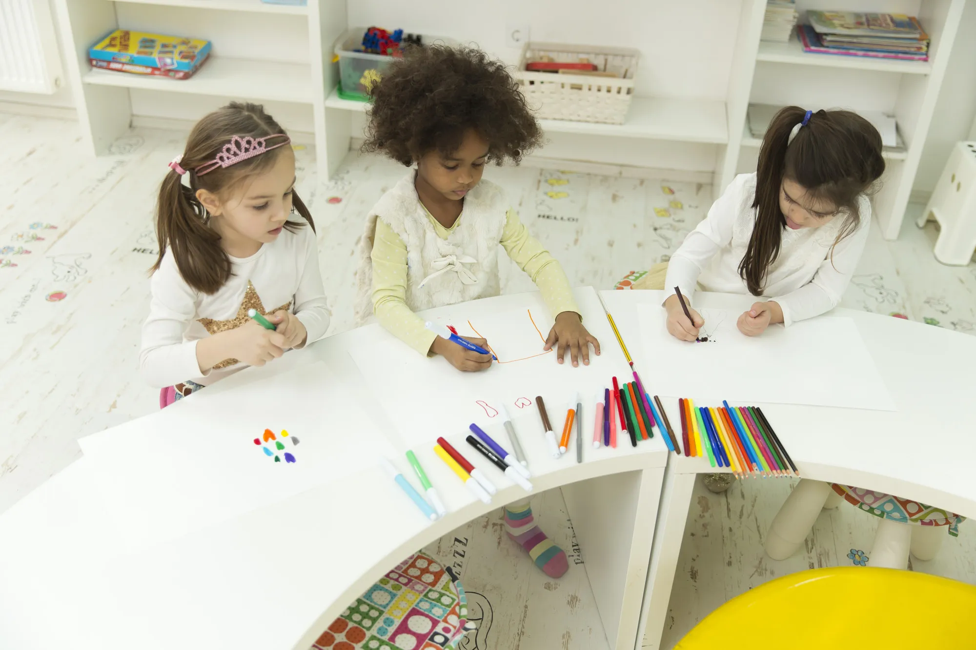 Multiracial children drawing in the playroom