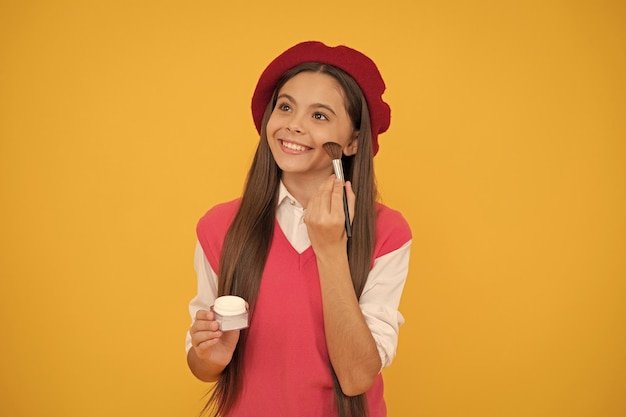 Natural female skin beauty tween and youth facial care happy french teen girl hold powder brush