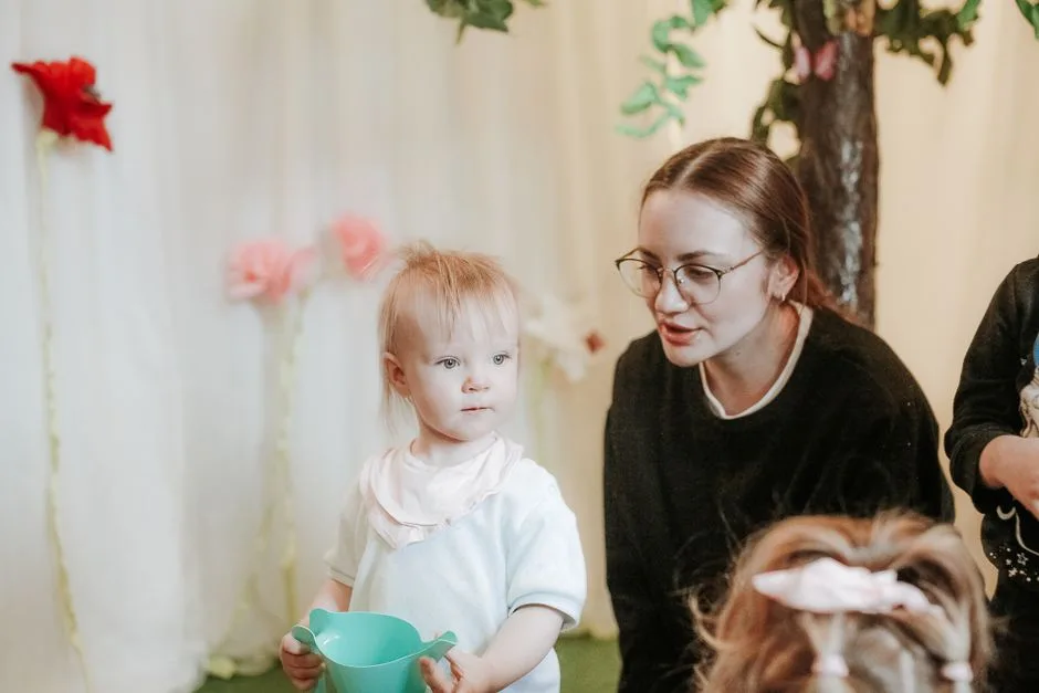 Cherished moment of a mother and child playing indoors with toys and vibrant decorations.
