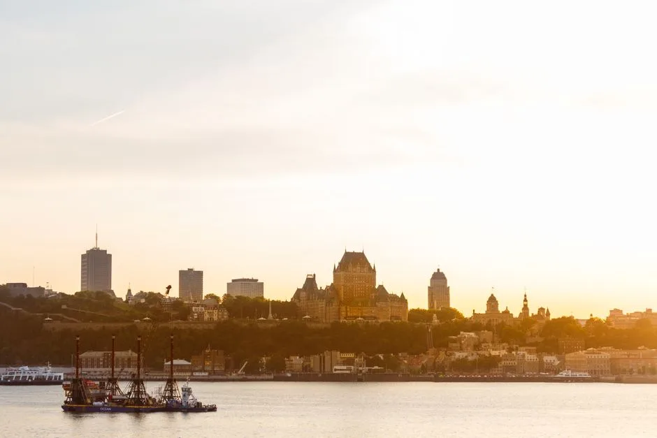 Scenic view of Québec City skyline at sunset featuring Château Frontenac and St. Lawrence River.