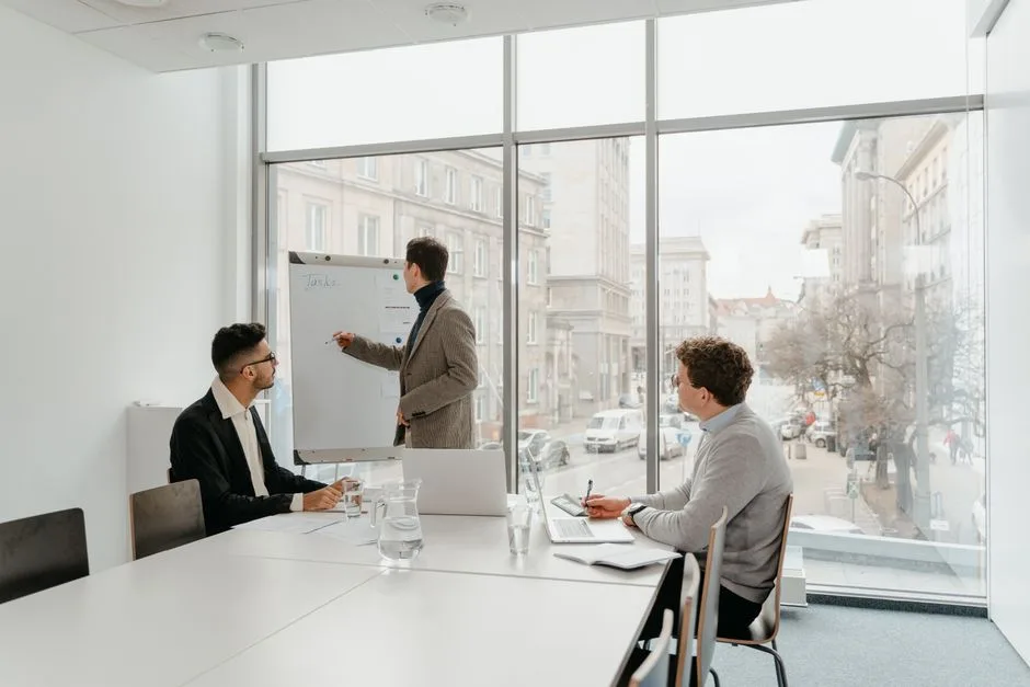 Three professionals engaged in a business meeting in a bright conference room.