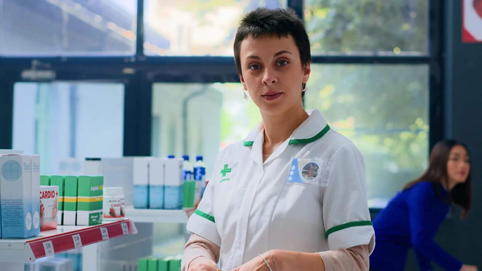 Portrait of cheerful pharmacist in apothecary preparing medicaments order for client. Smiling healthcare expert in drugstore placing cardiovascular pills in shopping bag for customer