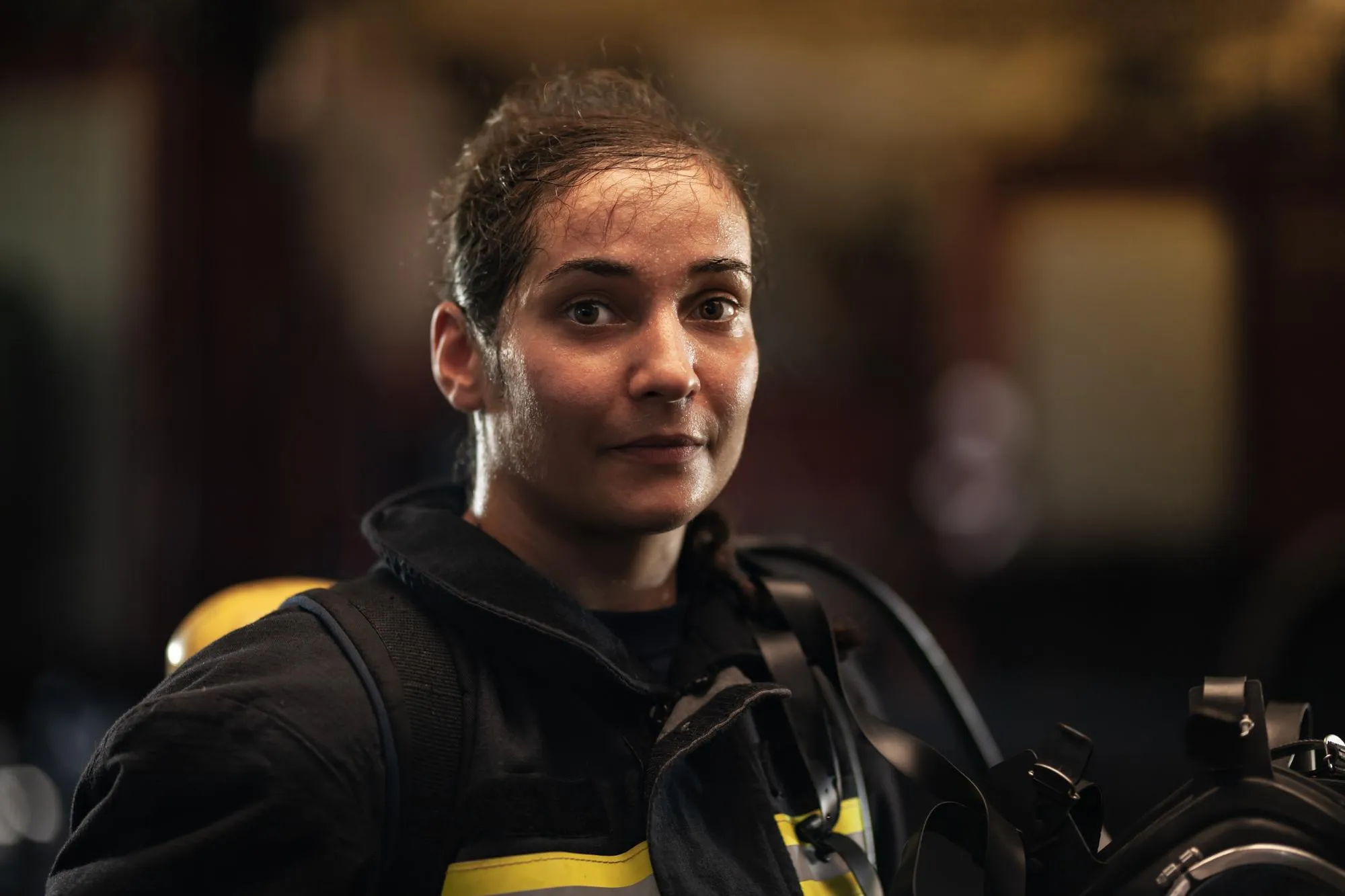 Portrait of female firefighter standing at station