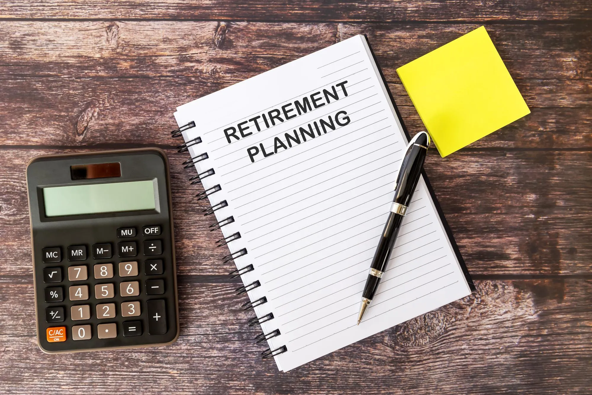 Retirement Planning on Note Pad With calculator and Pen