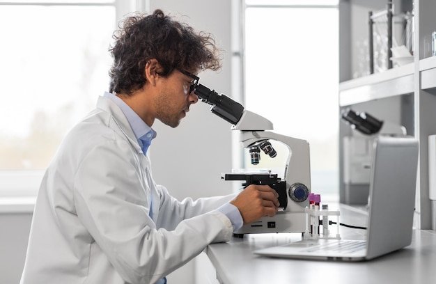 scientist with microscope working in laboratory