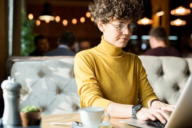 Serious hipster woman typing on laptop