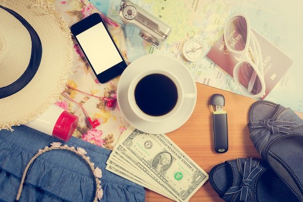 Set of travel accessory and costumes with coffee under warm light on wooden vintage background