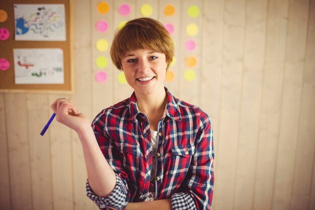 Smiling young woman posing with pen