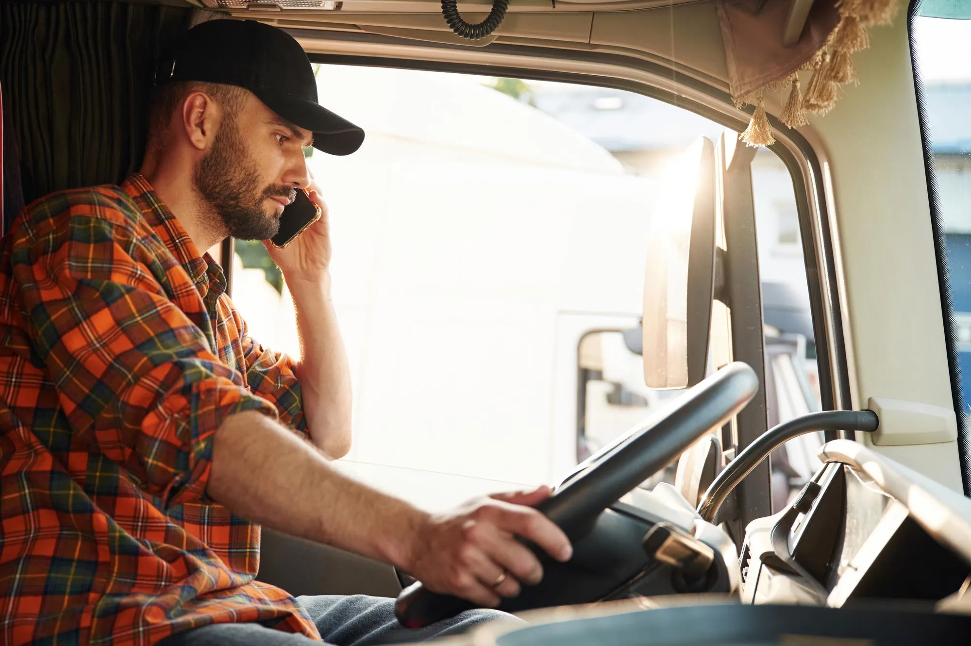 Talking by phone Young truck driver in casual clothes