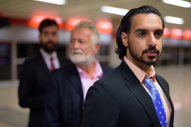 Three multi ethnic bearded businessmen together around the city