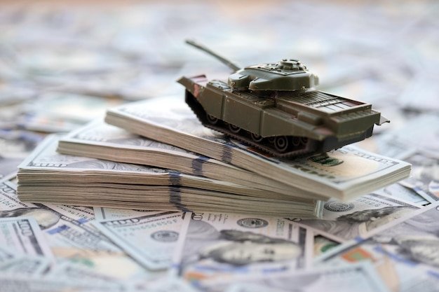 Toy tank on us hundred dollar bills banknotes the concept of war costs military spending and