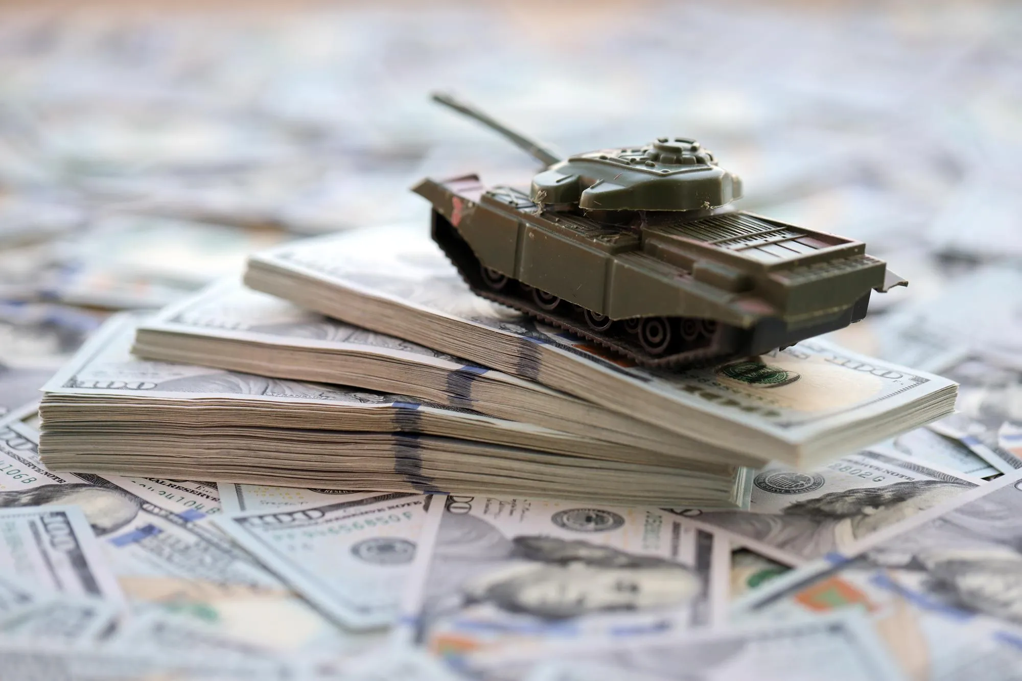 Toy tank on us hundred dollar bills banknotes the concept of war costs military spending and
