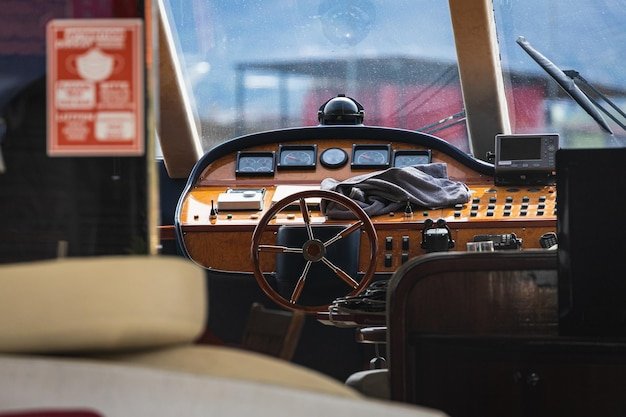 View of the varnished wooden steering wheel of a marine yacht control devices gauges button