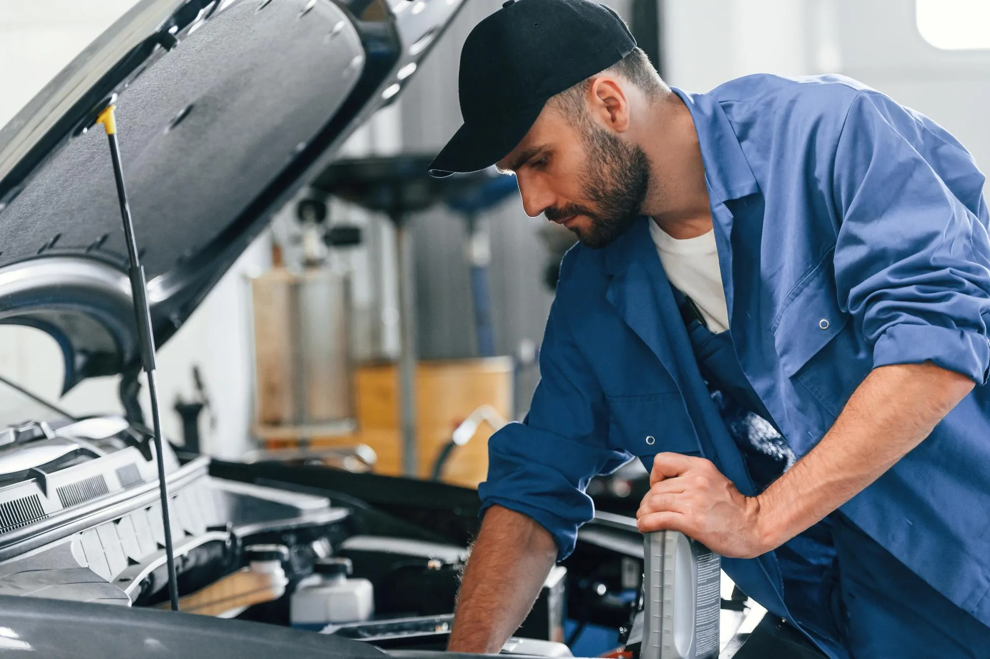 With fuel can Auto mechanic working in garage Repair service